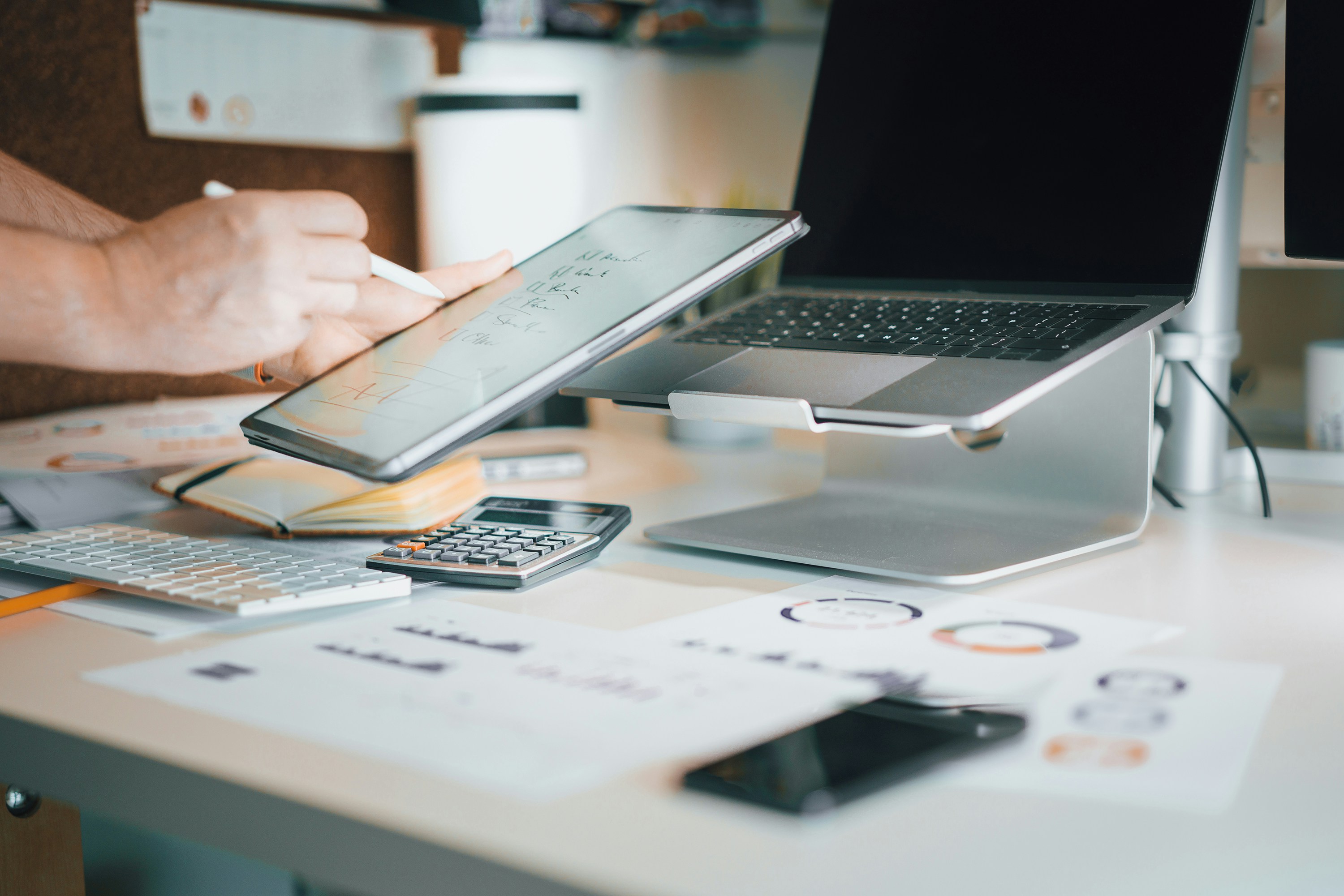 Laptop, calculator, and financial reports on a bright professional desk