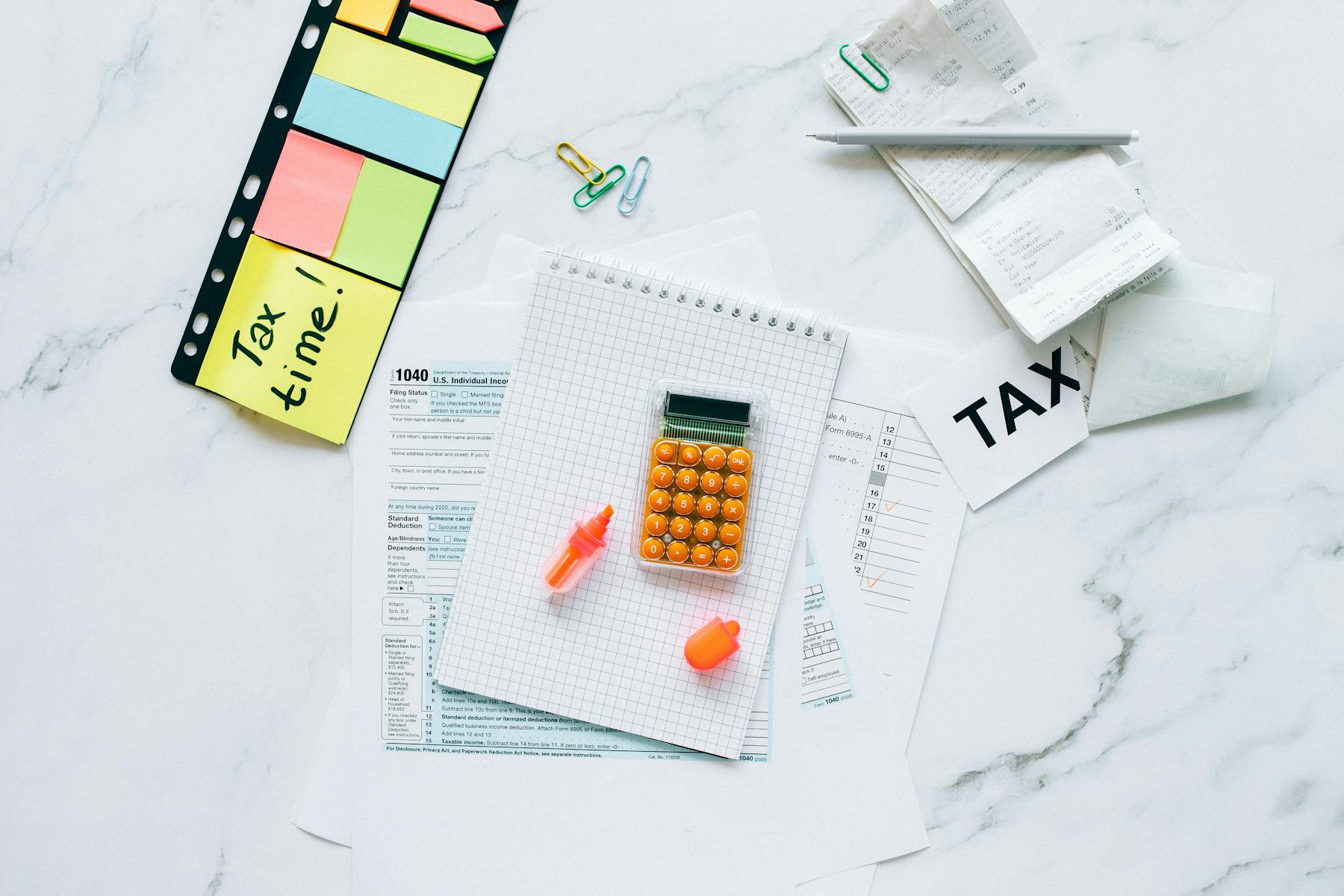 Tax documents, calculator, and preparation notes on a clean desk